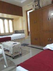 a room with two beds and a cabinet in it at Kodali Homestays in Bhadrāchalam