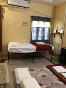 a room with two beds and a window at Kodali Homestays in Bhadrāchalam