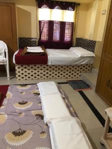 two beds in a room with towels on the floor at Kodali Homestays in Bhadrāchalam