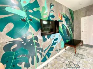 sala de estar con una pared colorida y TV en Studio Apartment 12 in Thalang, en Ban Phak Chit