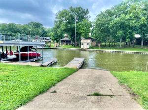 a boat is docked at a dock on a river at The Hickory House with Firepit- Boat Ramp Access to Cedar Creek Lake in Tool