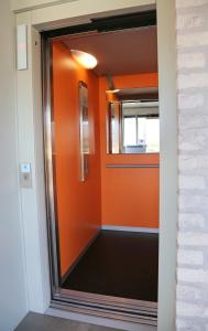 eine orangefarbene Wand in einem Zimmer mit Tür in der Unterkunft Logies Ternier in Nieuwpoort