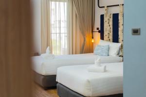 um quarto de hotel com duas camas e uma janela em W3 Hotel em Hat Yai