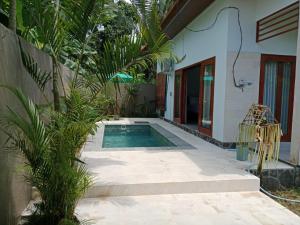 特賈庫拉的住宿－Villa Aditya，一座房子旁的院子内的游泳池