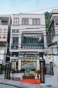 a white building with a store on a street at Harry Homestay in Cat Ba