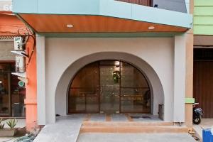 una entrada a un edificio con un arco en Urbanview Hotel R House Batuaji en Kubuk