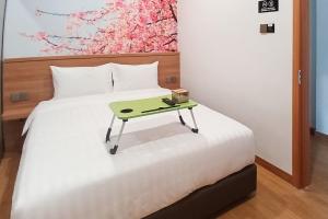 Una cama o camas en una habitación de Urbanview Hotel R House Batuaji