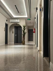 a hallway with a plant in the middle of a building at Golden Galaxies Furnished Units in Al Baha