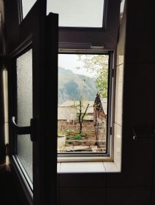an open window with a view of a house at Sanahin OLD&NEW in Alaverdi