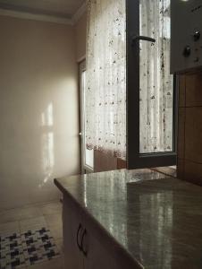 a kitchen with a counter and a window with curtains at Sanahin OLD&NEW in Alaverdi