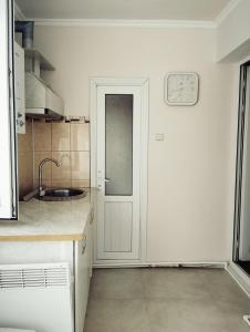 a kitchen with a door and a clock on the wall at Sanahin OLD&NEW in Alaverdi