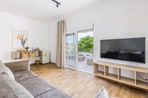 a living room with a couch and a large television at Forest view villa Skopelos in Skopelos Town