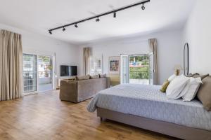 a white bedroom with a bed and a couch at Forest view villa Skopelos in Skopelos Town +25 photos