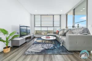 sala de estar con sofá y mesa en Aircabin - Burwood - Modern Comfy - 2 Beds Apt en Sídney