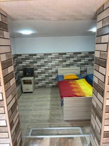 a bedroom with a bed and a brick wall at Downtown guest house in Kutaisi