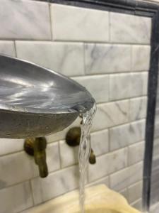 een stroom water uit een metalen gootsteen bij HERACITY Hotel in Pamukkale