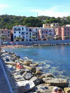 a group of people laying on the rocks near the water at Casa Bella 'Mbriana in Rio Marina