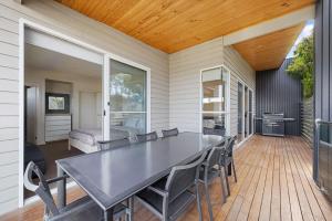 a dining room with a table and chairs on a patio at Sail Away Inlet Side in Inverloch