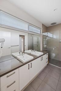 a large bathroom with two sinks and a shower at Sail Away Inlet Side in Inverloch