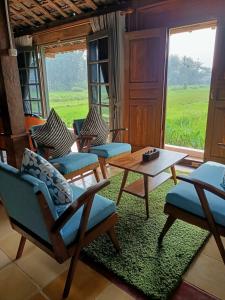 a living room with chairs and a table and a window at VILLACANTIK Yogyakarta triple bed for six persons in Bantul