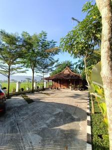 una carretera con un edificio y árboles en el fondo en VILLACANTIK Yogyakarta triple bed for six persons en Bantul