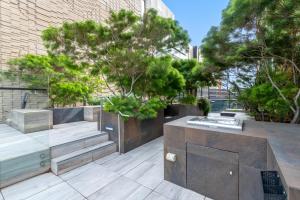 um jardim com bancos e árvores e um edifício em Sleek Inner-City 1-Bed Pad with Pool & BBQ em Melbourne