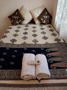 d'un lit avec des serviettes et un thermomètre. dans l'établissement Brand New Luxurious Flat in Kolkata City Centre, à Kolkata