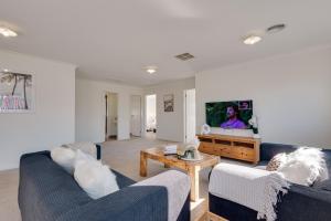 uma sala de estar com dois sofás e uma televisão em StayAU Cozy Holiday House 4BRM Big Group Tarneit em Tarneit