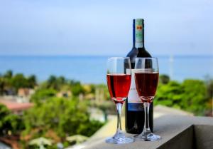 Dois copos de vinho ao lado de uma garrafa de vinho em Sea Wave Luxuy Apartment em Negombo