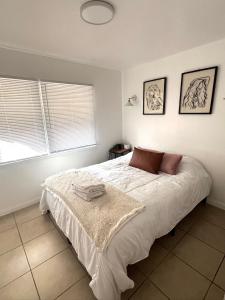 a bedroom with a bed with two towels on it at Modern Apartment near Disneyland & DTLA in Bellflower