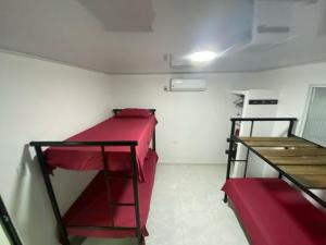 a small room with a bunk bed and a desk at 2 HABITACIONES EN CASA CAMPO GUACOCHE - 8PERSONAS A 12 MINUTOS DE VALLEDUPAR, CERCA PARQUE DE LA LEYENDa in Valledupar