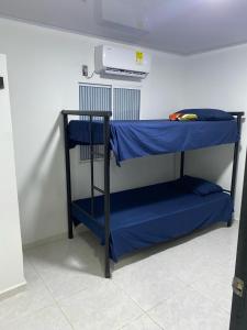 a bunk bed with blue sheets in a room at 2 HABITACIONES EN CASA CAMPO GUACOCHE - 8PERSONAS A 12 MINUTOS DE VALLEDUPAR, CERCA PARQUE DE LA LEYENDa in Valledupar
