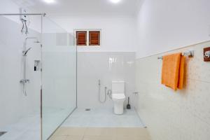 a white bathroom with a shower and a toilet at Treetop Resort By Scenery Villas in Dharga Town