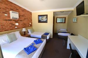 a hotel room with two beds and a tv at Narooma Motel in Narooma