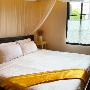 Bee Friend Boutique Guesthouse في شيانغ ماي: غرفة نوم مع سرير أبيض كبير مع نافذة