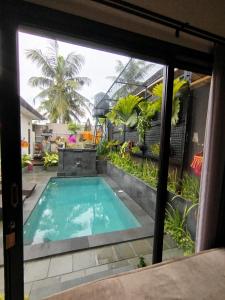vistas a la piscina desde la ventana de una casa en Meliora bali villa, en Ubud
