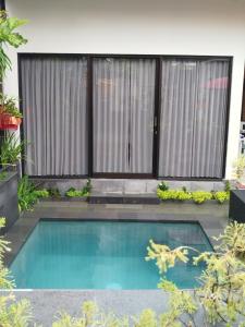 una piscina frente a una casa con un edificio en Meliora bali villa, en Ubud