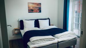 ein Bett mit einer blauen Decke und Kissen darauf in der Unterkunft Plesners Badehotel-Lejligheder in Skagen