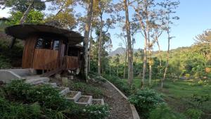 a tree house in the woods with a porch at Eco Conservation Landak Luxury Tents in Bukit Lawang