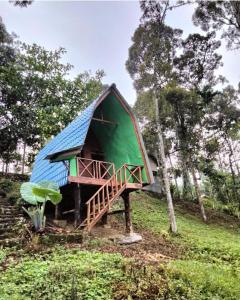 a small house with a blue roof on a hill at Eco Conservation Landak Luxury Tents in Bukit Lawang