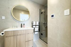 een badkamer met een wastafel en een spiegel bij Modern 4 Bedrooms Townhouse in Epsom in Auckland