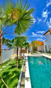 eine Villa mit einem Pool und Palmen in der Unterkunft Beautiful Villa mediterranean in Canggu