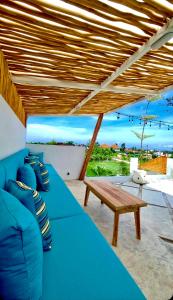 eine blaue Couch und ein Holztisch auf einer Terrasse in der Unterkunft Beautiful Villa mediterranean in Canggu