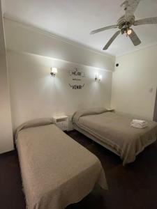 a room with two beds and a ceiling fan at Hotel Lobo de Mar - Centro in Mar del Plata