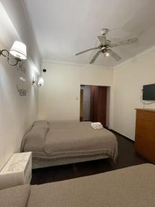 1 dormitorio con 1 cama y ventilador de techo en Hotel Lobo de Mar - Centro en Mar del Plata