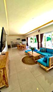 ein Wohnzimmer mit einem blauen Sofa und einem TV in der Unterkunft Beautiful Villa mediterranean in Canggu