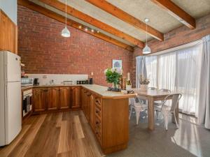 een keuken met een tafel en een bakstenen muur bij Beautiful Bala in Shepparton