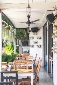 an outdoor patio with wooden tables and chairs at Kata Station Boutique Hotel in Kata Beach