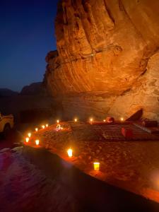 a cave with lights in front of a cliff at Bedouin Memories Camp in Wadi Rum