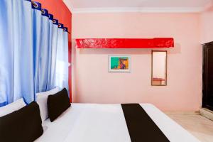 OYO Hotel Abhilasha في Bhilai: غرفة نوم بسرير ابيض ونافذة
